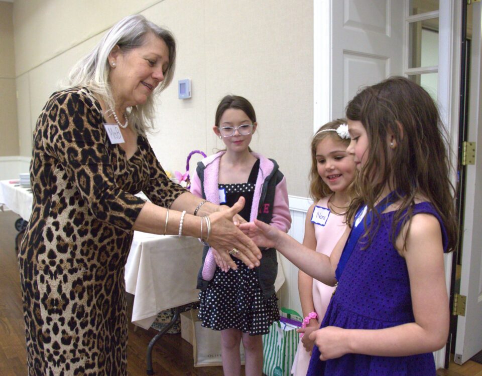 Teacher demonstrating children how to properly shake hands