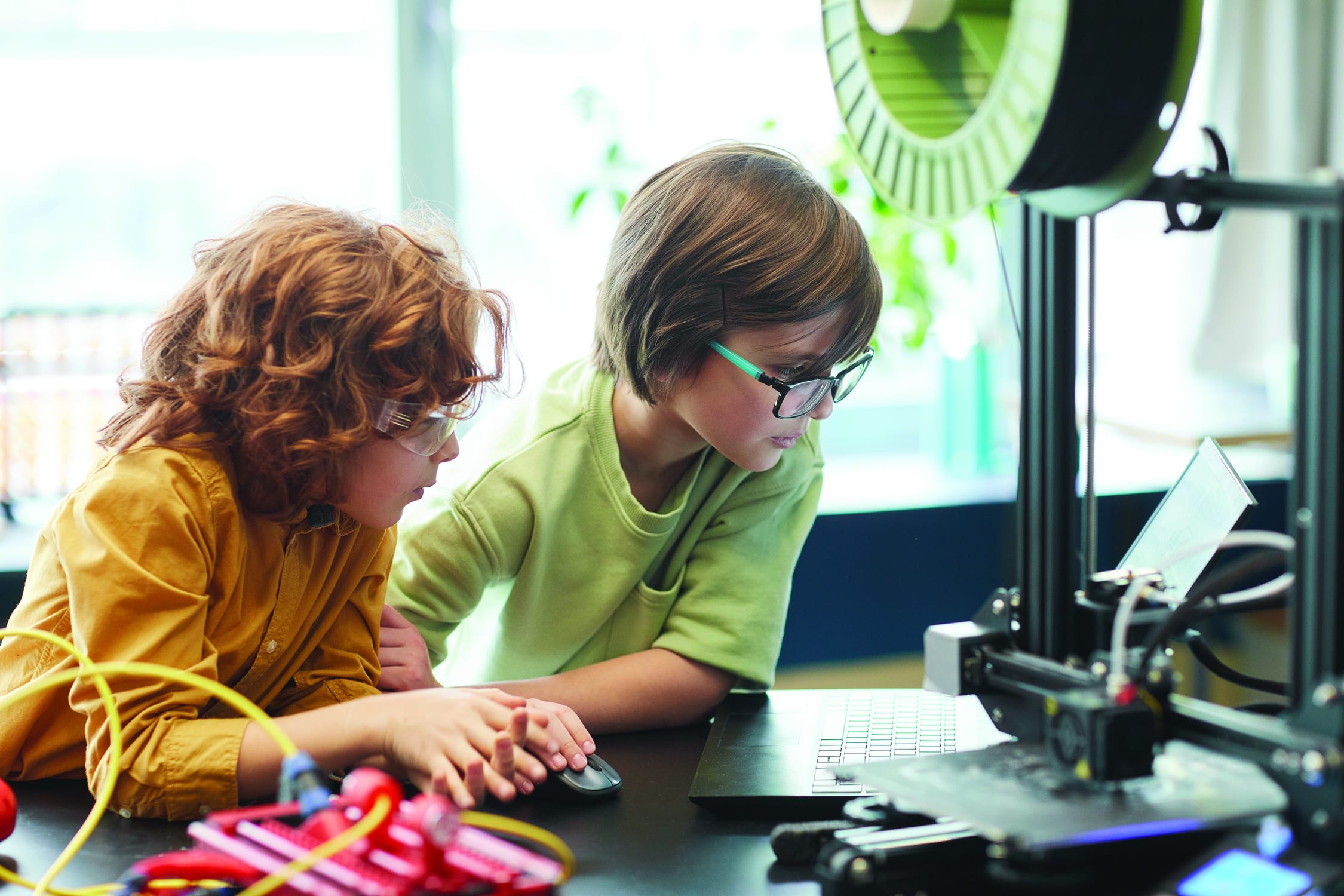 Two boys using a 3D printer