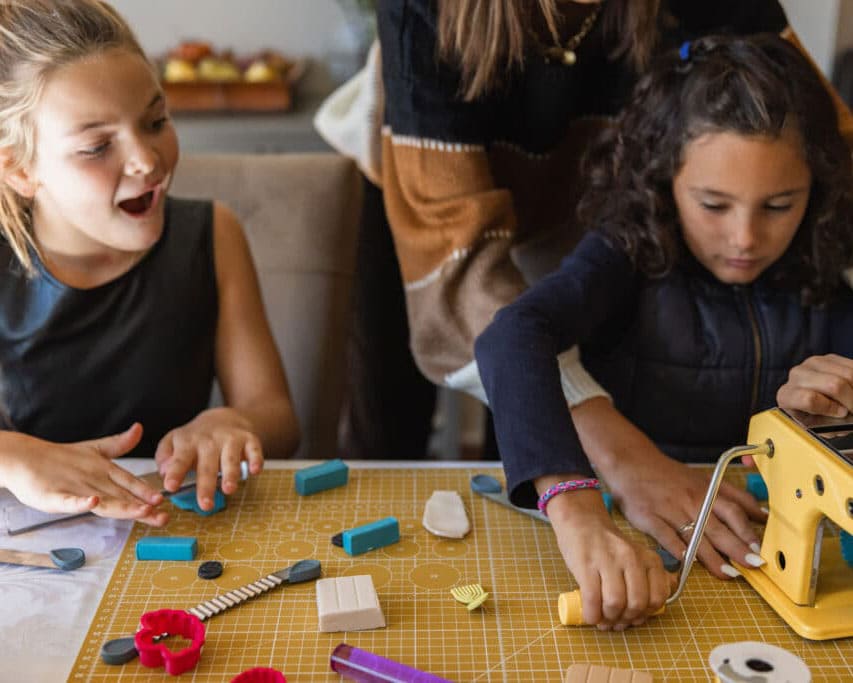 Two young girls making jewelry