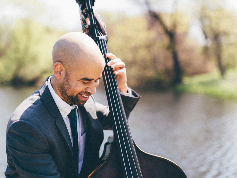 Christian Dillingham plays jazz bass beside a body of water