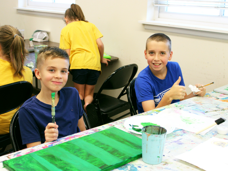 Two boys painting with acrylic paint at Art Camp