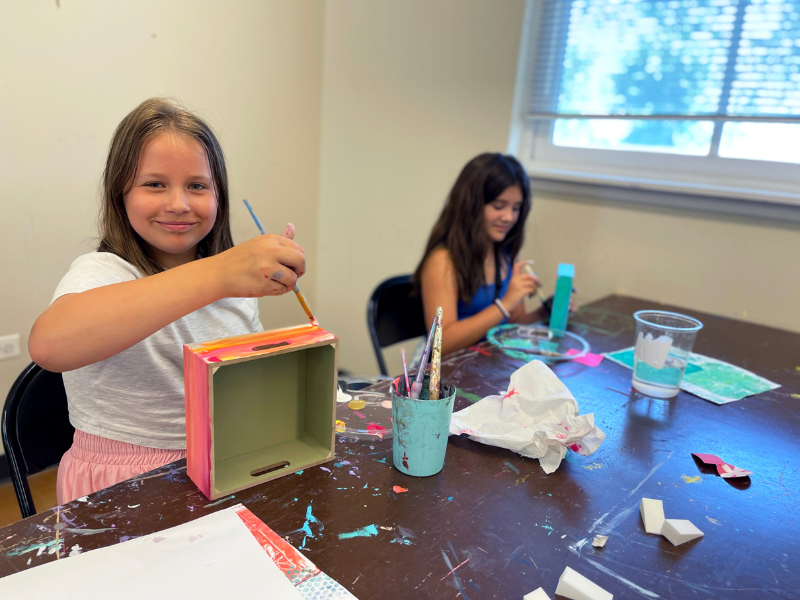 Two girls painting a project in art camp