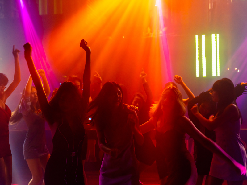 Women dancing in a club with colorful lights