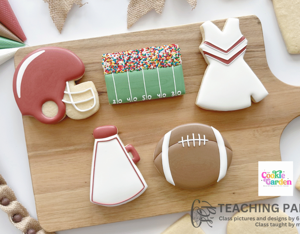 5 cookies on wooden cutting board decorated to look like a football helmet, football field sideline, a cheerleader outfit, a football and a megaphone.