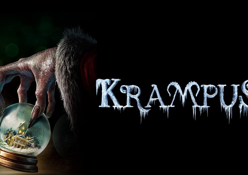 Promotional poster for the movie "Krampus"- a hand with long fingers and wrinkled skin is picking up a small snow globe with a holiday scene inside of it