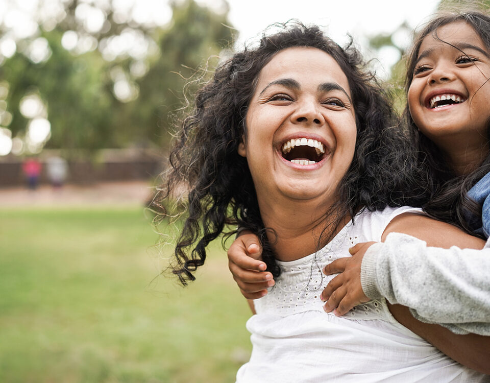 Happy mom and daughter outside laughing