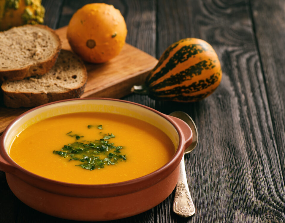 Homemade pumpkin cream soup on black background.