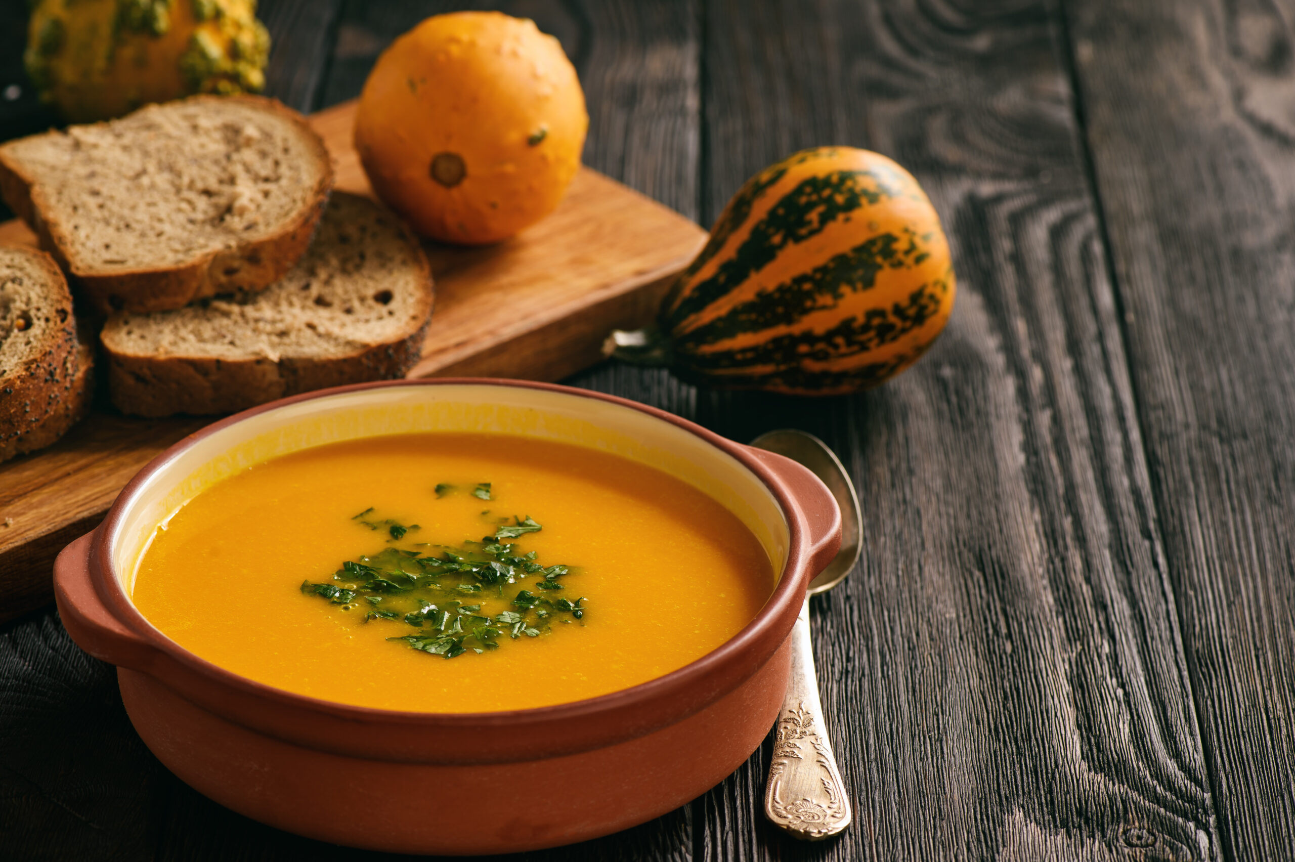 Homemade pumpkin cream soup on black background.