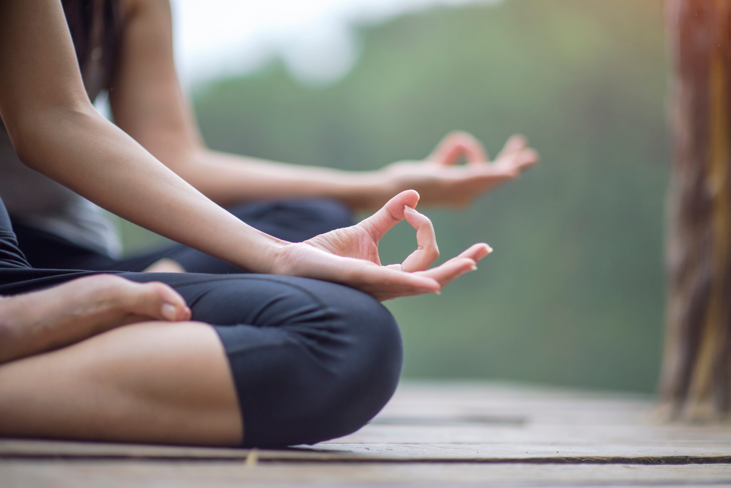 Woman yoga finger acting on hands in soft focus background with Nature surrounding