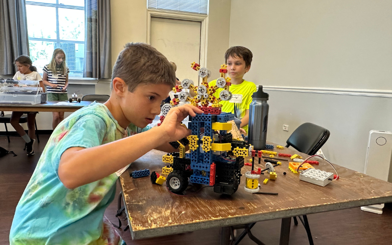 Tween Boys and Girls build multi-colored RoboThink battle robots in a camp at Gorton