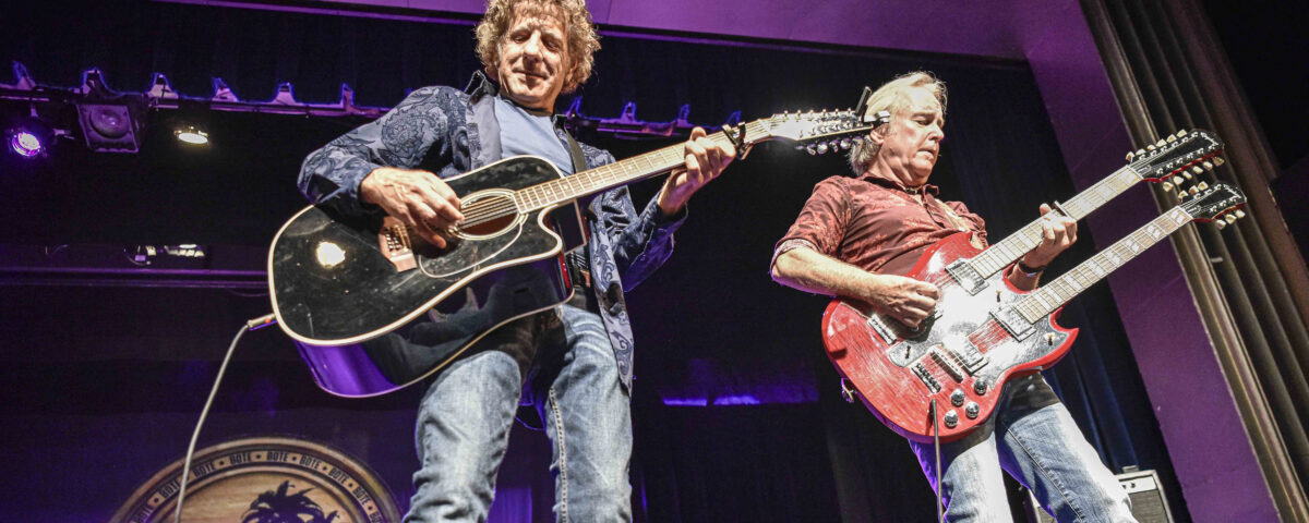 Two members of Best of The Eagles Tribute band plaing guitars on stage