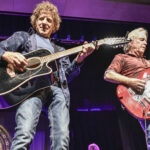 Two members of Best of The Eagles Tribute band plaing guitars on stage