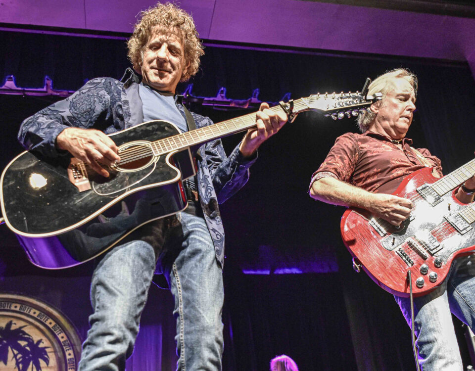 Two members of Best of The Eagles Tribute band plaing guitars on stage