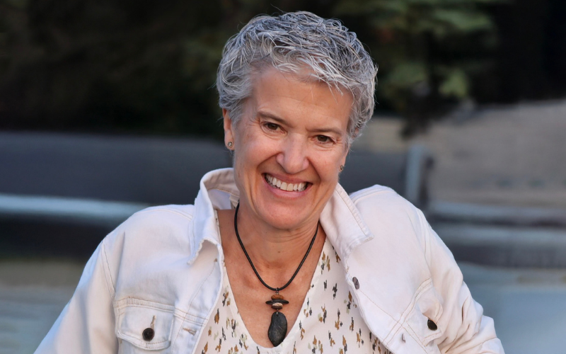 Gail Gamrath, smiling woman with short hair wearing a white jean jacket