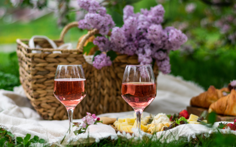 picnic basket with lilacs and wine glasses with rose