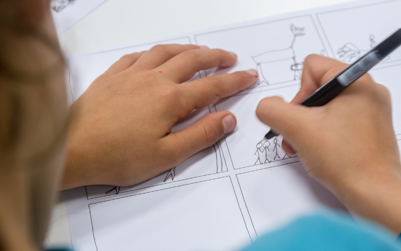 Tween-aged youth drawing comics at comics lab camp