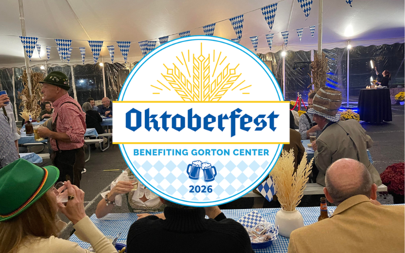 people dressed in traditional German clothing in an Oktoberfest tent drinking beer with friends