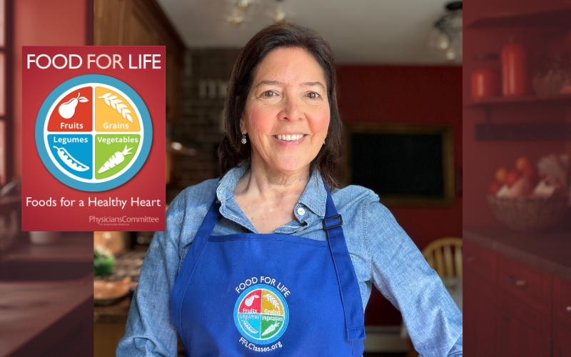 An image of Thais Boddick, wellness educator with Food for Life. She is standing in a kitchen wearing a blue apron with the Food for Life logo.