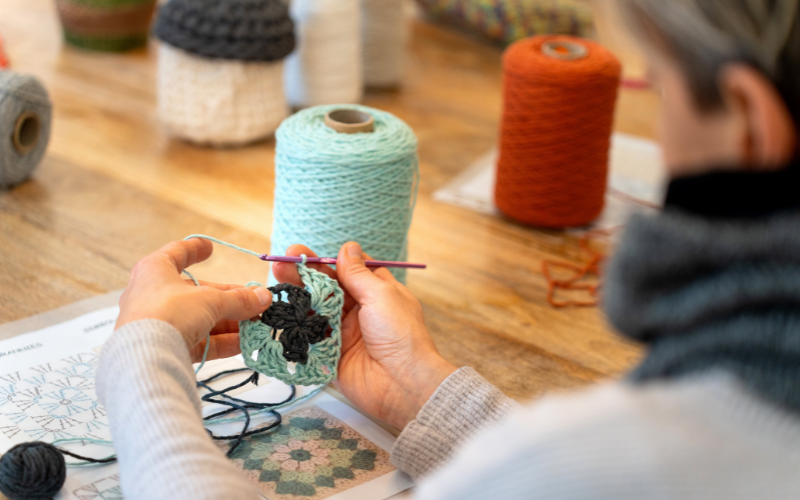 An up close image of someone working on a small, floral patterned piece in the Monthly Crochet Workshop